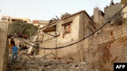 2024年6月21日，以色列對黎巴嫩南部靠近黎-以邊境的希亞姆村發動有針對性的空襲後，一名黎巴嫩男子走過被毀壞的房屋。 (法新社照片)