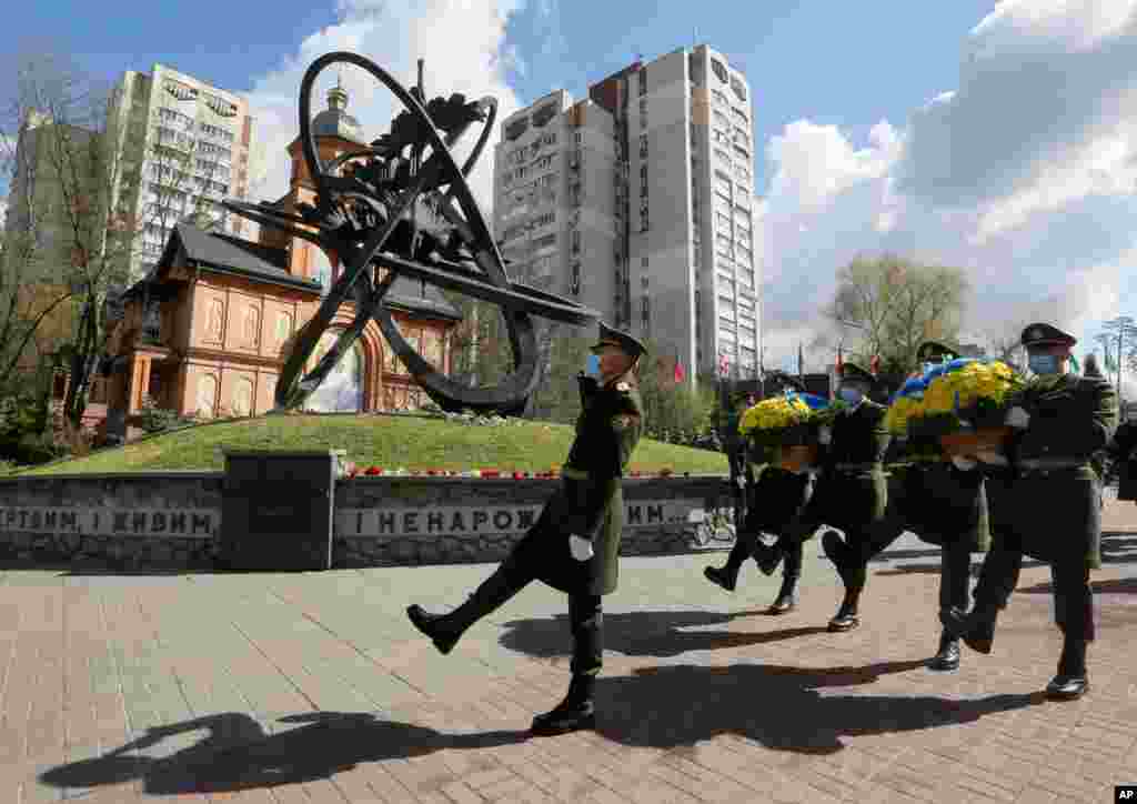 우크라이나 수도 키예프에서 체르노빌 원자력 발전소 사고 35주년을 맞아 의장대가 추모조형물에 헌화하고 있다. 지난 1986년 4월 26일 원전 폭발 사고로 방사능이 누출돼 수많은 주민들이 피해를 입었다.
