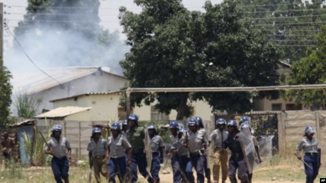 Police leave the scene after throwing teargas at a house in Chitungwiza, Zimbabwe, November 6, 2011.