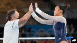 Sunisa Lee, of the United States, greets her coach Jeff Graba after performing on the uneven bars during the artistic gymnastics women's all-around final at the 2020 Summer Olympics, July 29, 2021, in Tokyo.