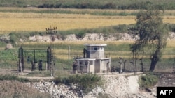 North Korean soldiers are seen at a military fence next to a guard post in the North Korean border county of Kaepoong, as seen across the Demilitarized Zone (DMZ) from the South Korean island of Ganghwa on Sept. 25, 2020. 