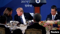 U.S. President Donald Trump and First Lady Melania talk during a state dinner hosted by South Korea's President Moon Jae-in (R) in his honor at the Blue House in Seoul, South Korea November 7, 2017. REUTERS/Jonathan Ernst TPX IMAGES OF THE DAY - RC1DE2208340