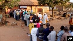 People line up at a polling station to cast their votes in Bissau, Guinea-Bissau, April 13, 2014.