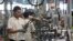 FILE - Employees work on an assembly line at the General Motors Powertrain-Uzbekistan plant in Tashkent, Aug. 31, 2012.