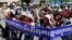 Cambodian activists shout slogans during a march toward the National Assembly, in Phnom Penh, Cambodia, Thursday, May 29, 2014. Some 300 activists on Thursday delivered petitions to the National Assembly and Anti-Corruption Unit headquarters to demand the government to stop giving land concession to private companies. The banner reads " Absolutely against the corruption in the society." (AP Photo/Heng Sinith)