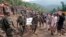 Army soldiers and rescue workers recover bodies of landslide victims even as they try to pull out two buses that were covered in mud after a landslide in Urla village, Himachal Pradesh state, India, Aug. 13, 2017. 
