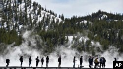 Para pengunjung terlihat di lokasi mata air Grand Prismatic di Taman Nasional Yellowstone, di Wyoming, pada 1 Maret 2021. (Foto: AP/Iris Samuels)