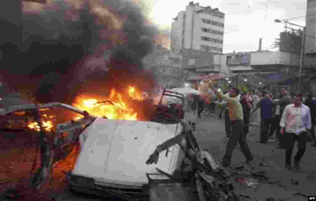 A Palestinian pours water on a burning car destroyed in an explosion in Gaza City, Wednesday, Nov. 17, 2010. Hamas officials say one person has been killed and four others wounded in a car explosion in the Gaza Strip. Hamas media reported the car was hit 