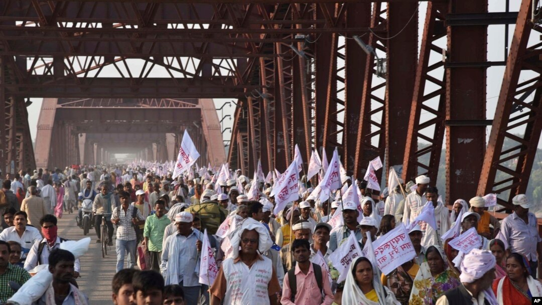 Peziarah Hindu membawa bendera-bendera keagamaan dan berjalan di jembatan yang padat orang setelah sebelumnya terjadi insiden orang terinjak-injak di jembatan yang sama (15/10/2016). Varanasi, India. (foto: AP Photo)