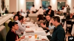 People eating at Gotham restaurant in New York City on December 14, 2021. (AP Photo/Brittainy Newman)