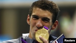 Michael Phelps mencium medali ke-19 setelah tim renang AS meraih emas dalam nomor renang 4x200 meter berantai putera (31/7). Phelps memecahkan rekor pesenam Soviet Larisa Latynina yang meraih 18 medali selama olimpiade.