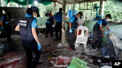 FILE - Police inspect the scene of a shooting at a security checkpoint in Yala province, Thailand, Nov. 6, 2019.