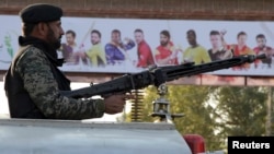 A Pakistani paramilitary soldier monitors the area near an entry gate of Gaddafi stadium for the final cricket match of Pakistan Super League, in Lahore, Pakistan, Saturday, March 4, 2017.