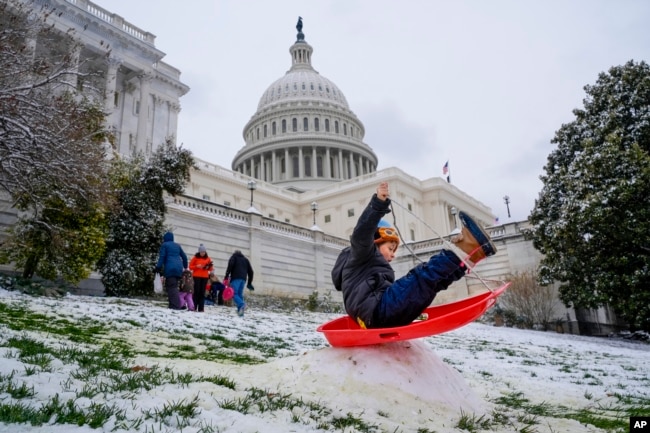 FILE - Silvestre, 6, of Washington, sleds over a snow bump on the hill at the U.S. Capitol, as schools are closed due to a winter storm, Tuesday, Jan. 16, 2024. (AP Photo/Jacquelyn Martin)