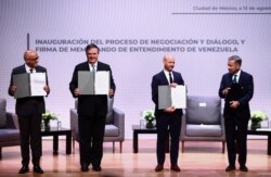 Participantes muestran el Memorando de Entendimiento firmado de Venezuela en el marco de la proceso de negociación y diálogo, durante una reunión para buscar consensos sobre cómo superar las crisis económicas y sociales que azotan a Venezuela. ​