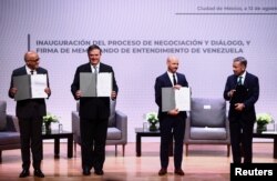 Participantes muestran el Memorando de Entendimiento firmado de Venezuela en el marco de la proceso de negociación y diálogo, durante una reunión para buscar consensos sobre cómo superar las crisis económicas y sociales que azotan a Venezuela. ​