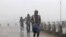 People run for shelter as heavy rain and wind gusts rip through the Bay of Bengal coast at Gopalpur, Orissa, about 285 kilometers (178 miles) north east of Visakhapatnam, India, Sunday, Oct. 12, 2014. 