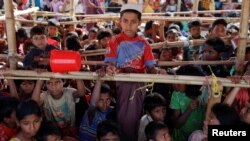 FILE - Rohingya refugees rest at a transit center for new arrivals at Kutupalong refugee settlement near Cox's Bazar, Bangladesh, Dec. 1, 2017. 