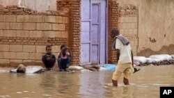A man wades through a flooded street in the town of Shaqilab, about 25 kilometers southwest of the capital, Khartoum, Sudan, Aug. 31, 2020.
