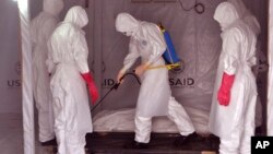 Petugas kesehatan membersihkan bekas tempat jenazah seorang pria yang meninggal akibat ebola di pusat perawatan ebola di Monrovia, Liberia (28/11).