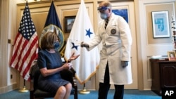 Doktor Dr. Brian Monahan, pomoćni ljekar Capitola, sa predsjedavajućom Predstavničkog doma Nancy Pelosi, 18. decembrar 2020.