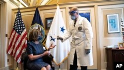 Dr. Brian Monahan, attending physician Congress of the United States, gives Speaker of the House Nancy Pelosi, D-Calif., a medical card after she received a Pfizer-BioNTech COVID-19 vaccine shot in Washington, Dec. 18, 2020.