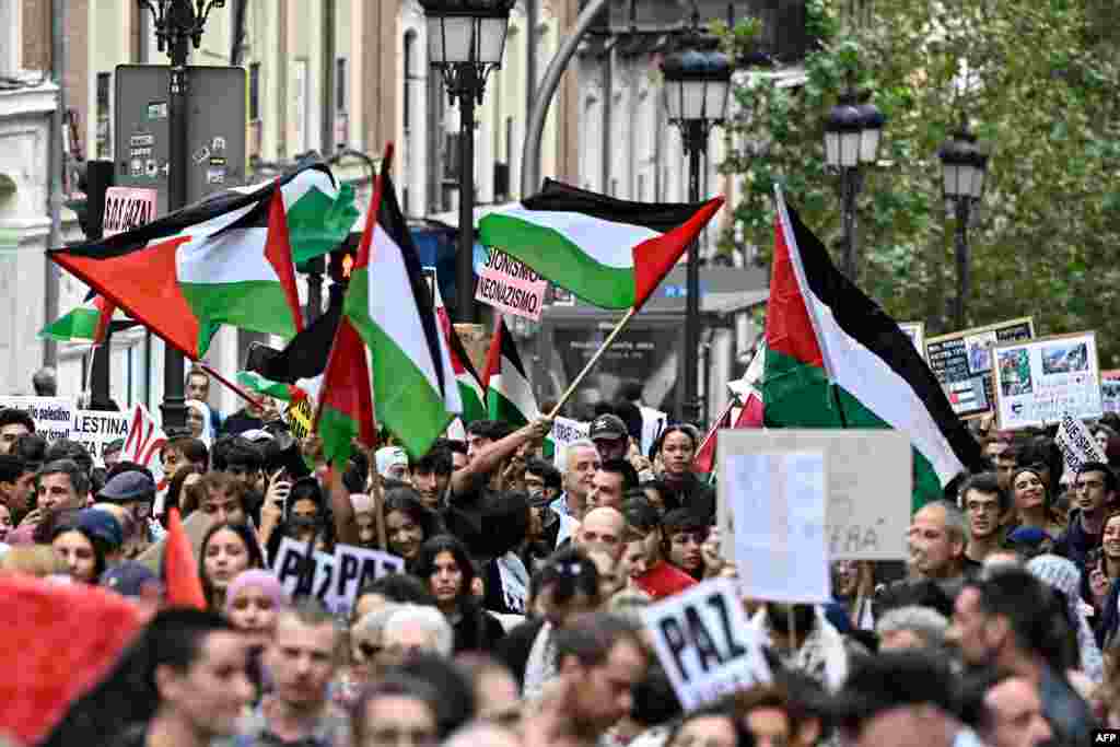 Waandamanaji wakipeperusha bendera ya Palestina na mabango yenye maandishi yanayoiunga mkono watu wa Palestina mjini Madrid, Oktoba 15, 2023.