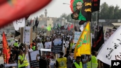 Saudis marching in a funeral procession carry religious flags and signs blaming the fundamentalist Wahhabi stream of Sunni Islam's ideology for recent suicide attacks on Shi'ite mosques in the kingdom, May 30, 2015, in Tarut, Saudi Arabia.