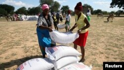 Villagers queue to collect their monthly food aid ration of cereals at a school in drought hit Masvingo, Zimbabwe, June 2, 2016. 