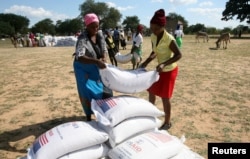 Villagers queue to collect their monthly food aid ration of cereals at a school in drought hit Masvingo, Zimbabwe, June 2, 2016.