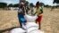 Villagers queue to collect their monthly food aid ration of cereals at a school in drought hit Masvingo, Zimbabwe, June 2, 2016. 