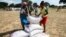 FILE: Villagers queue to collect their monthly food aid ration of cereals at a school in drought-hit Masvingo, Zimbabwe, June 2, 2016. 