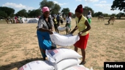 FILE - Villagers queue to collect their monthly food aid ration of cereals at a school in drought-hit Masvingo, Zimbabwe, June 2, 2016. 