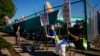 FILE - Boeing 737 Max aircrafts are seen behind fences as striking Boeing workers picket on Sept. 24, 2024, next to the company's facilities in Renton, Washington. Analysts say strikes and two hurricanes kept employers from adding many jobs in October.