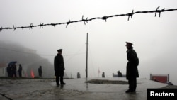 FILE - Chinese soldiers guard the Nathu La mountain pass, between Tibet and the tiny northeastern Indian state of Sikkim, July 6, 2006.