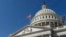 FILE - an American flag flies over Capitol Hill in Washington. 