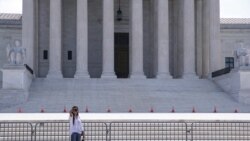 FILE - A woman takes a photo outside the Supreme Court building in Washington, June 21, 2021.