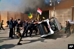 Protesters damage property inside the U.S. embassy compound, in Baghdad, Iraq, Tuesday, Dec 31, 2019.