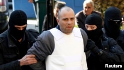 FILE - Nikos Maziotis (C) is escorted by policemen to a prosecutor's office in Athens April 12, 2010.