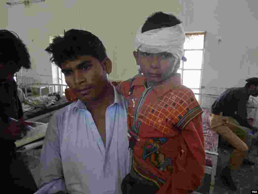 A man carries a boy who was injured in a passenger train that derailed after it was hit by a bomb attack, at a hospital in Dera Murad Jamali, Baluchistan province, Pakistan, Oct. 21, 2013. 