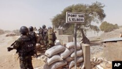 FILE - Cameroonian soldiers guard against Boko Haram militants on Elbeid bridge near the village of Fotokol, on the border with Nigeria's Borno state. Militant attacks have fed demand for private security firms, now the focus of a government clampdown.