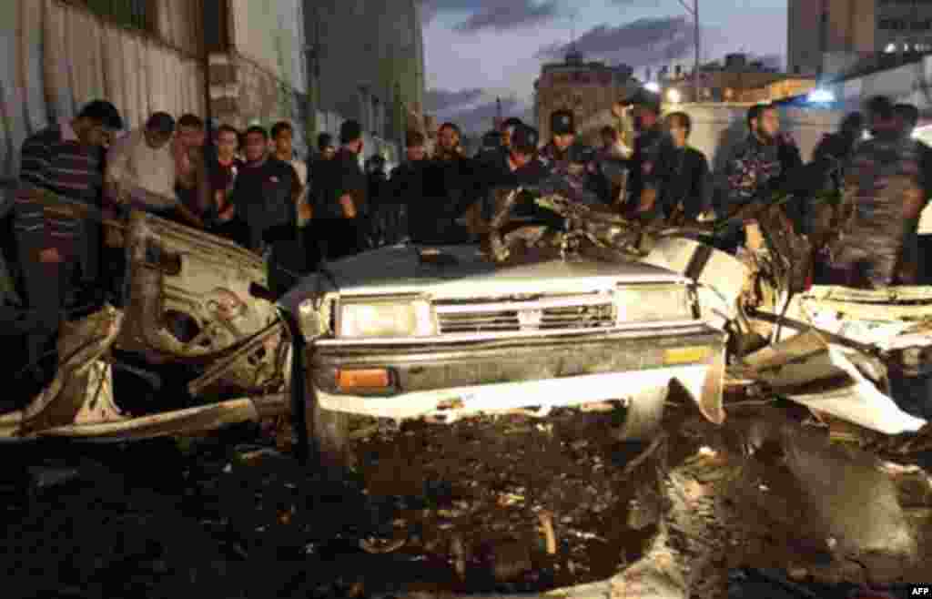 Palestinians gather around a destroyed car after an explosion in Gaza City, Wednesday, Nov. 17, 2010. Hamas officials say one person has been killed and four others wounded in a car explosion in the Gaza Strip. Hamas media reported the car was hit in an a