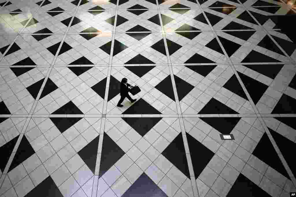 A man wearing a face mask to help stop the spread of the coronavirus walks at a building in Tokyo.