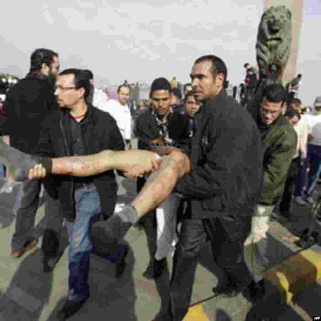 Egyptian anti-government activists carry a wounded man during clashes with police in Cairo, Egypt, Friday, Jan. 28, 2011. Tens of thousands of anti-government protesters poured into the streets of Egypt Friday, stoning and confronting police who fired bac