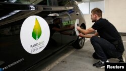 Gambar tempel Konferensi Perubahan Iklim COP21 di Paris pada mobil listrik Nissan LEAF di Boulogne-Billancourt, dekat Paris (16/11). (Reuters/Benoit Tessier)