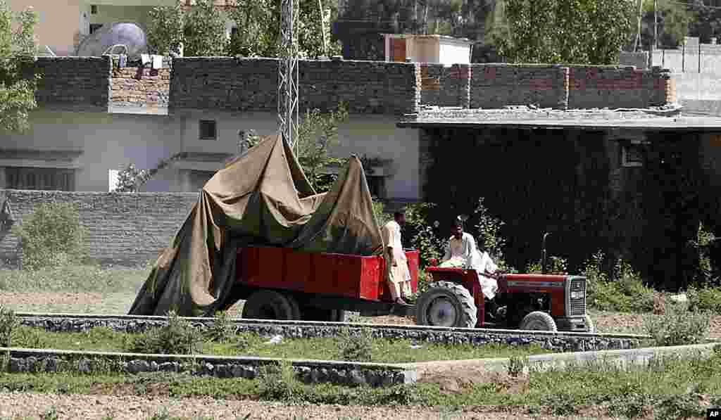This May 2, 2011 file photo shows a tractor trolley carrying the wreckage of a helicopter that crashed next to the wall of Osama bin Laden&#39;s compound, Abbottabad, Pakistan.&nbsp;