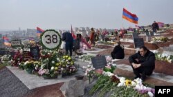 Orang-orang mengunjungi kuburan kerabat mereka yang terbunuh dalam konflik Karabakh di Yerevan pada 12 Desember 2020. (Foto: AFP)