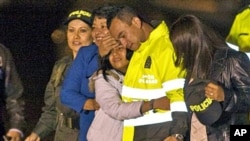 Former hostage Carlos Alberto Ocampo, second right, is reunited with family members upon his arrival to a military airport in Bogota, Colombia after his release by the Revolutionary Armed Forces of Colombia, FARC, February 13, 2011