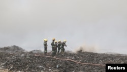 Firefighters work to extinguish a fire in a landfill outside Yangon, Myanmar, April 23, 2018. The landfill has been taking garbage for 17 years, and the fire has burned into its second week.