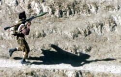 FILE - A fighter armed with a Soviet-made RPG-7 rocket launcher runs towards his position in Northern Afghanistan, Oct. 14, 2001. A U.S. company is selling a redesigned and updated version of the Soviet RPG-7 anti-tank weapon to Ukraine.